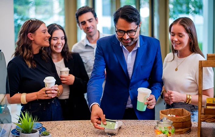 Un commerçant présente son DAB afin que le client puisse régler