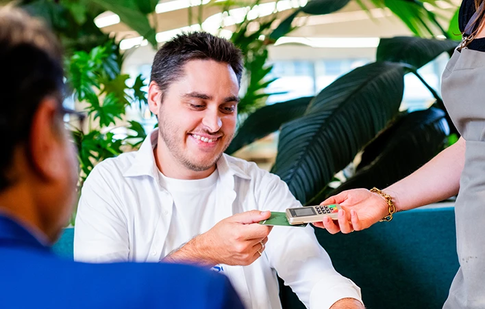 Un groupe de personne paye son café sur un TPE