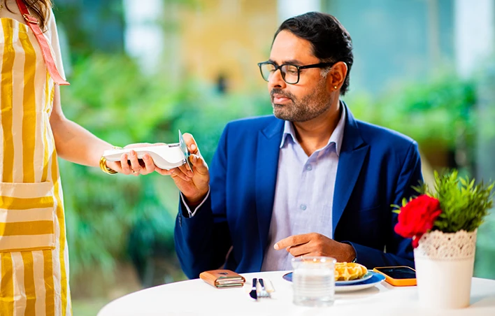 Un homme effectue un paiement avec sa carte sur un TPE